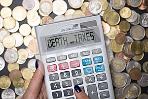 Death and taxes phrase on calculatorÃ¢â¬â¢s display, suggesting that nothing is certain but death and taxes, English expression photo